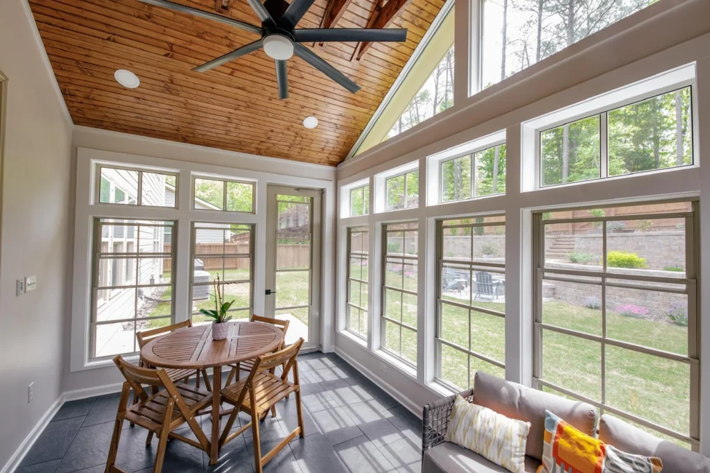 Four-season sunroom addition in Cary, NC with vaulted tongue-and-groove
wood ceiling, full-height windows, and tile floor by AG Construction Management