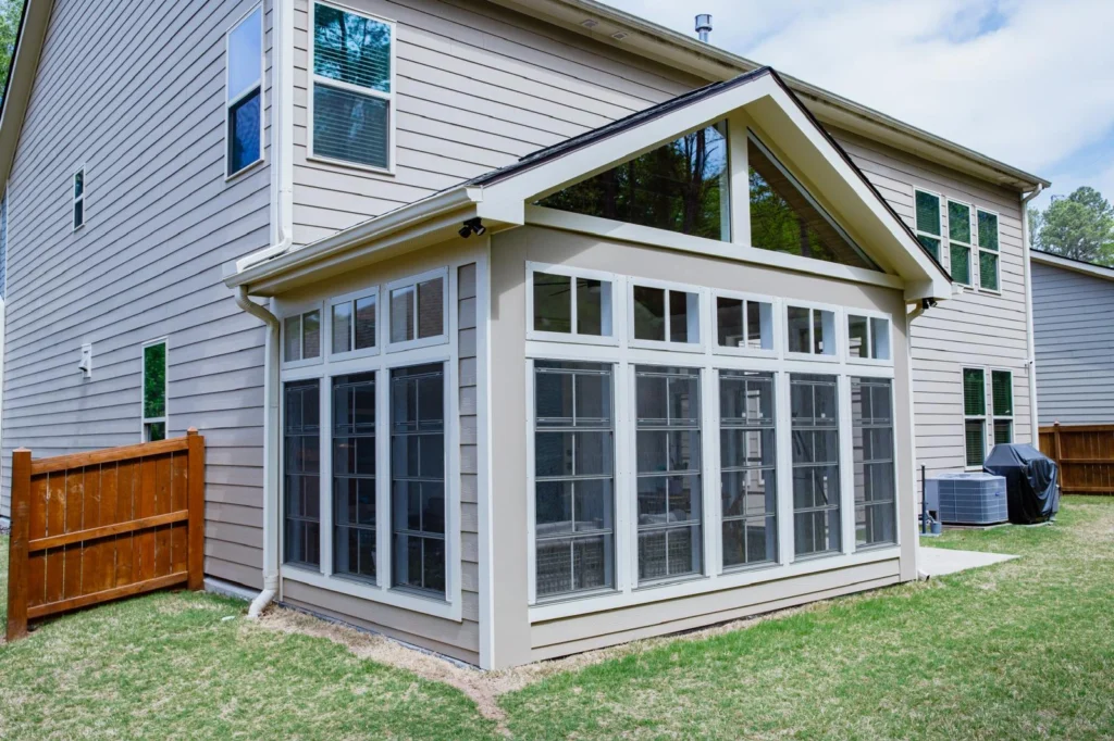 Exterior of a four-season sunroom addition in Cary, NC with a gable roof
tied into the existing home and full-height windows