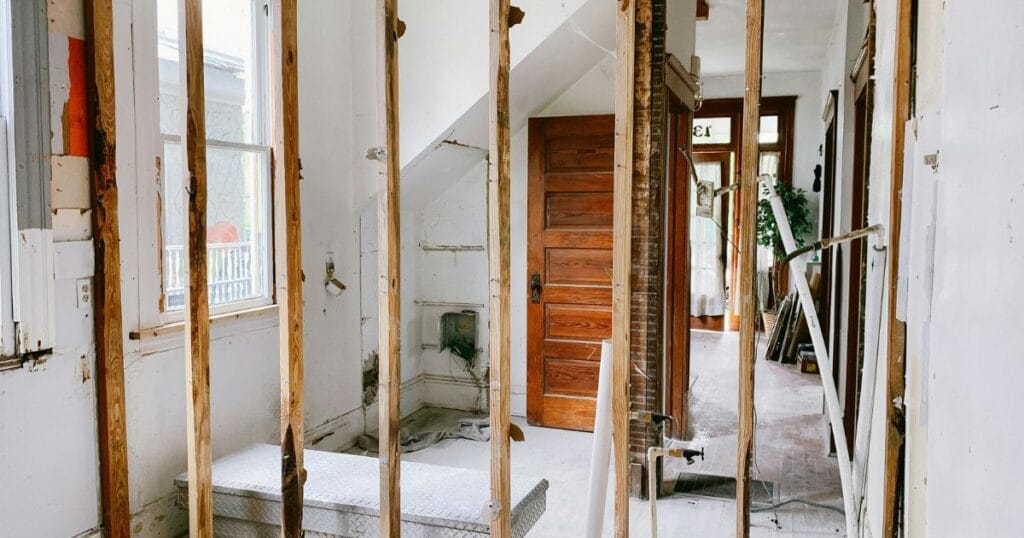 Home remodeling wall demo showing exposed studs for an upstairs bedroom